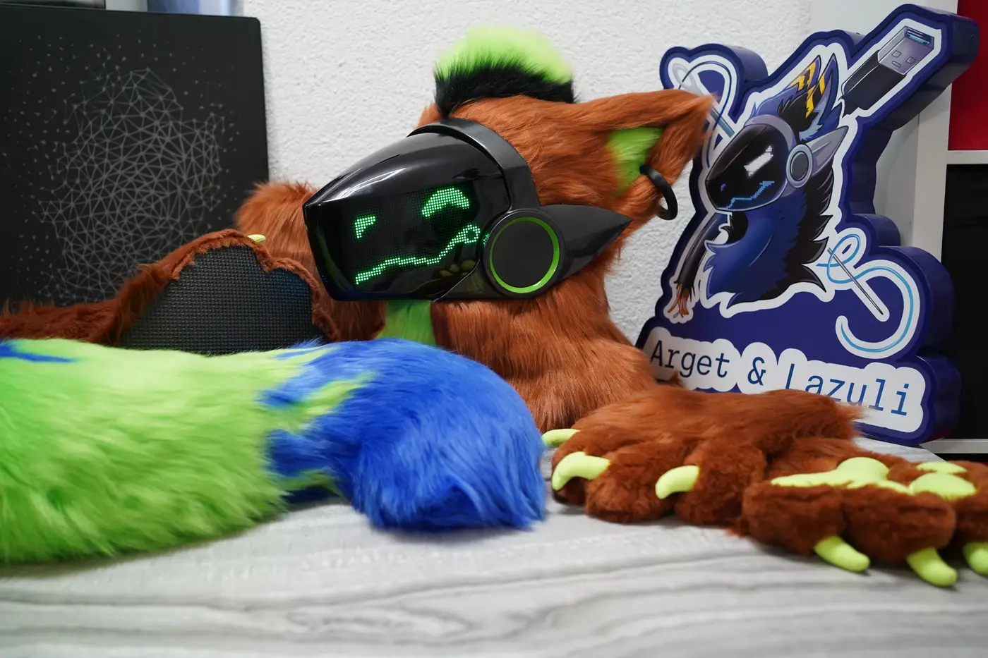 Rust brown Protogen partial with the head, a large green and blue canine shaped tail, hand paws with green claws and outdoor feet paws