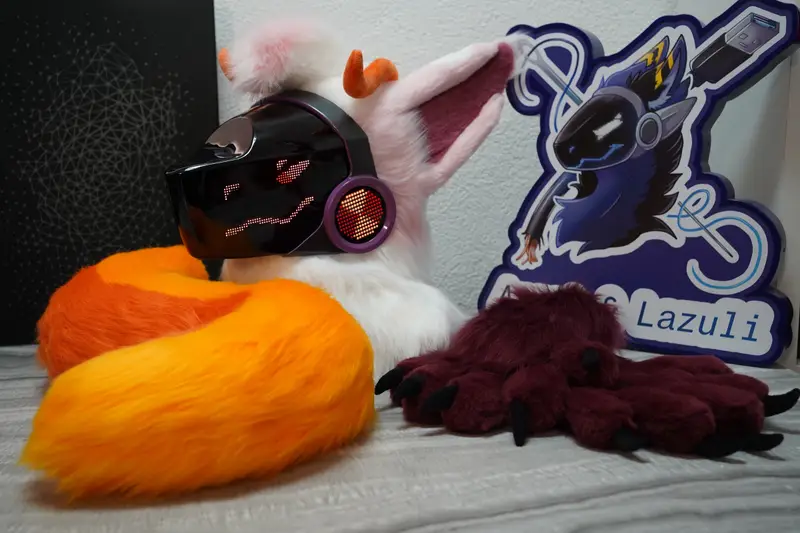 White and pink Protogen head, burgundy hand paws and orange tail with the Arget and Lazuli logo