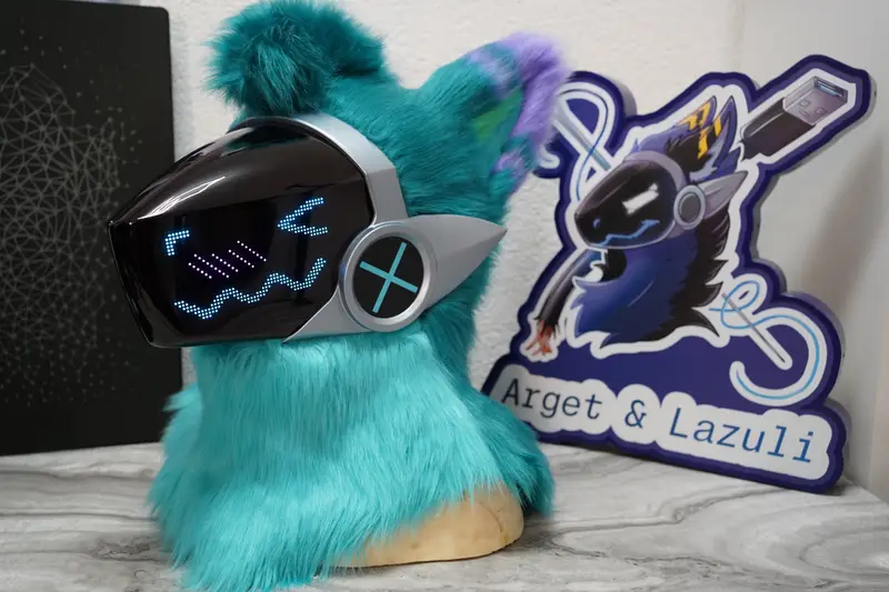 Turquoise Protogen head with purple ear tufts and a blue face on the silver framed LED visor