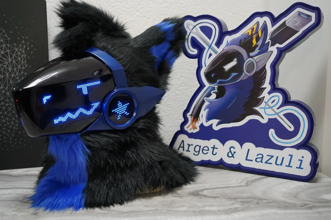 Black Protogen head with square blue eyes and a wavy mouth on the LED visor