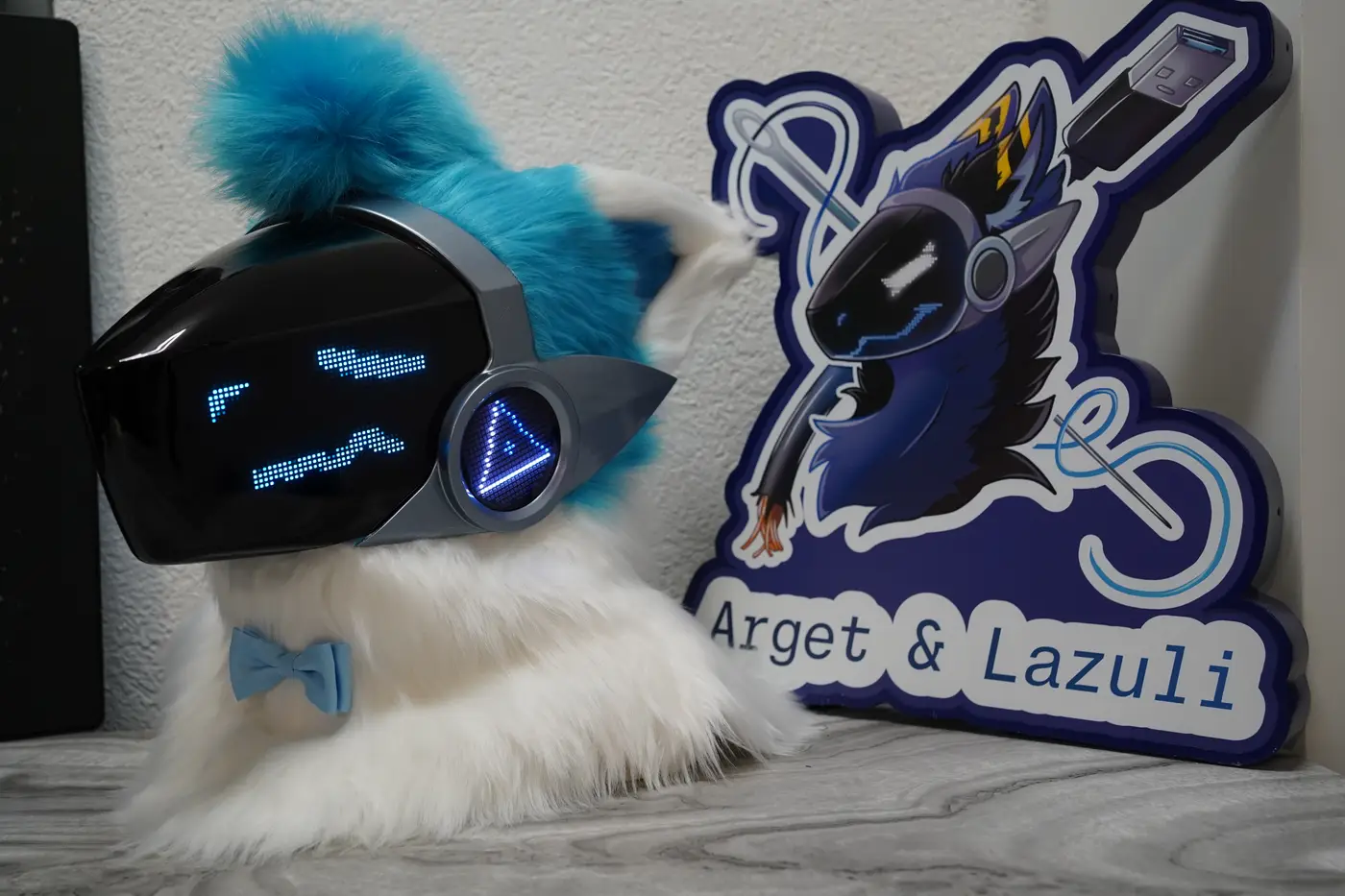 White Protogen head with blue pixel eyes and a zigzag mouth on the black LED visor