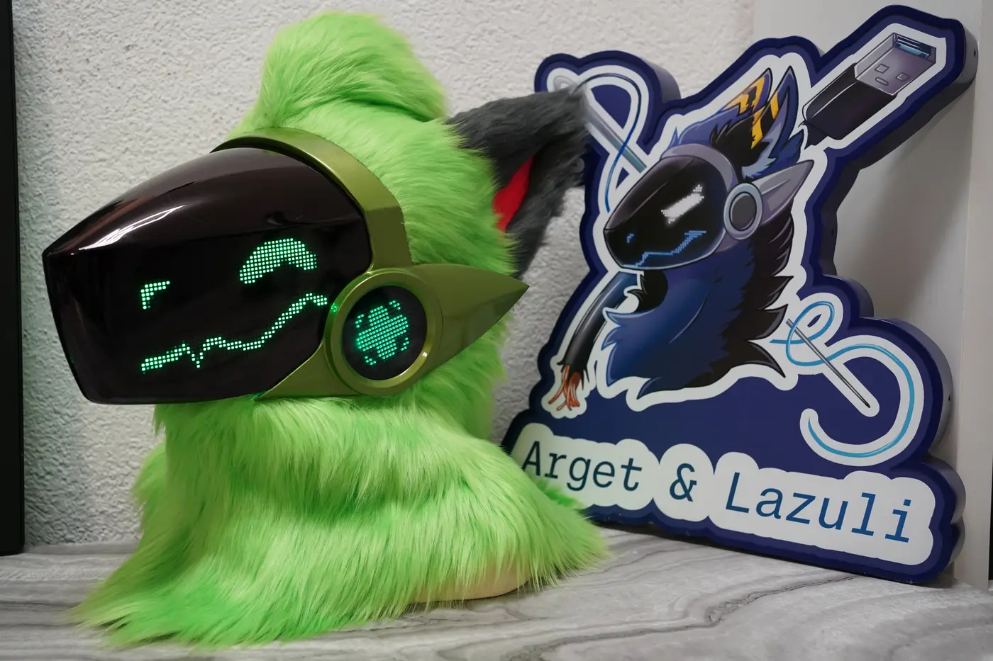 Lime green Protogen head with an olive green shell, green pixel eyes and a wavy mouth on the black LED visor