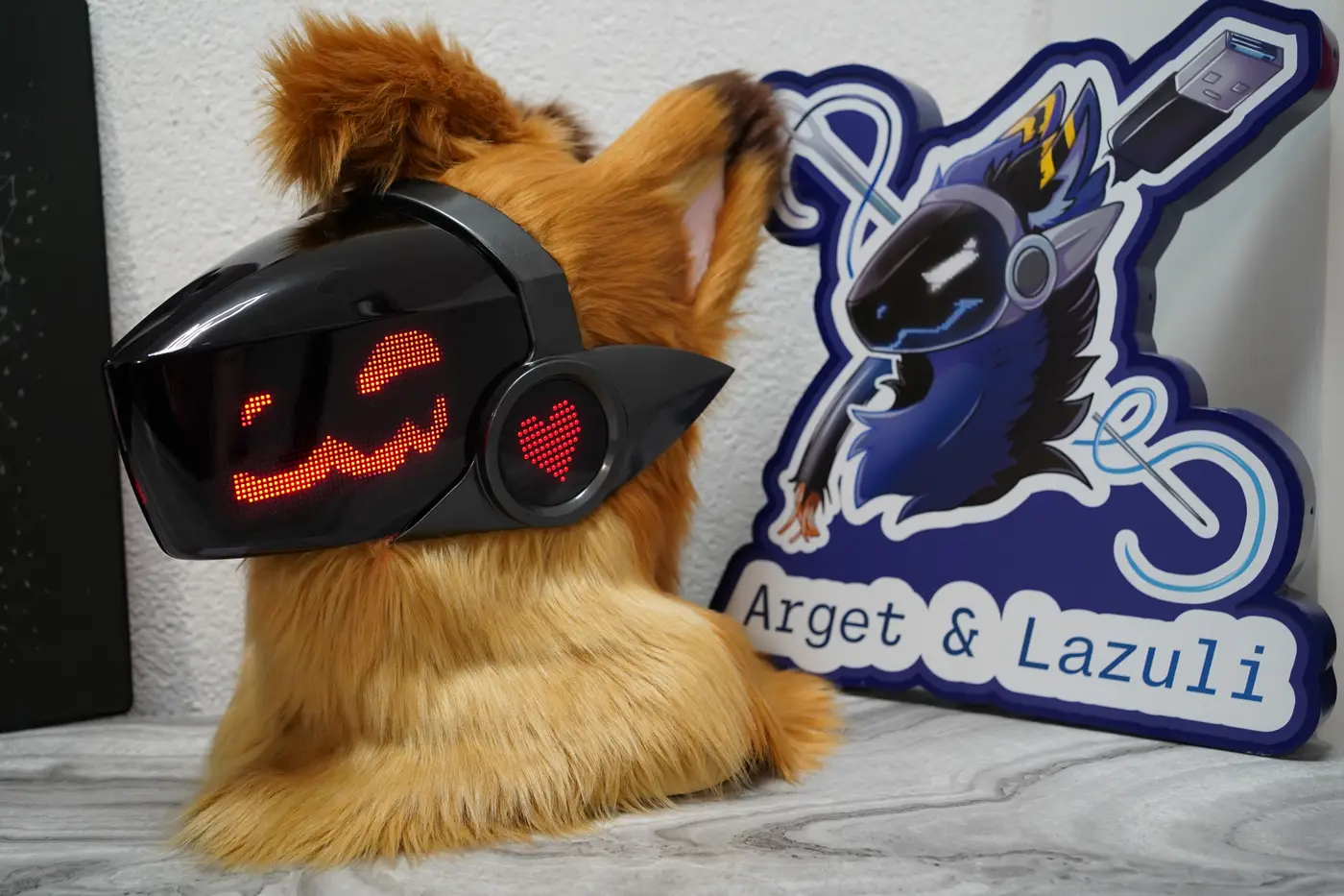 Tan Protogen head with a red pixel grin and a heart on the cheek disc of the black LED visor
