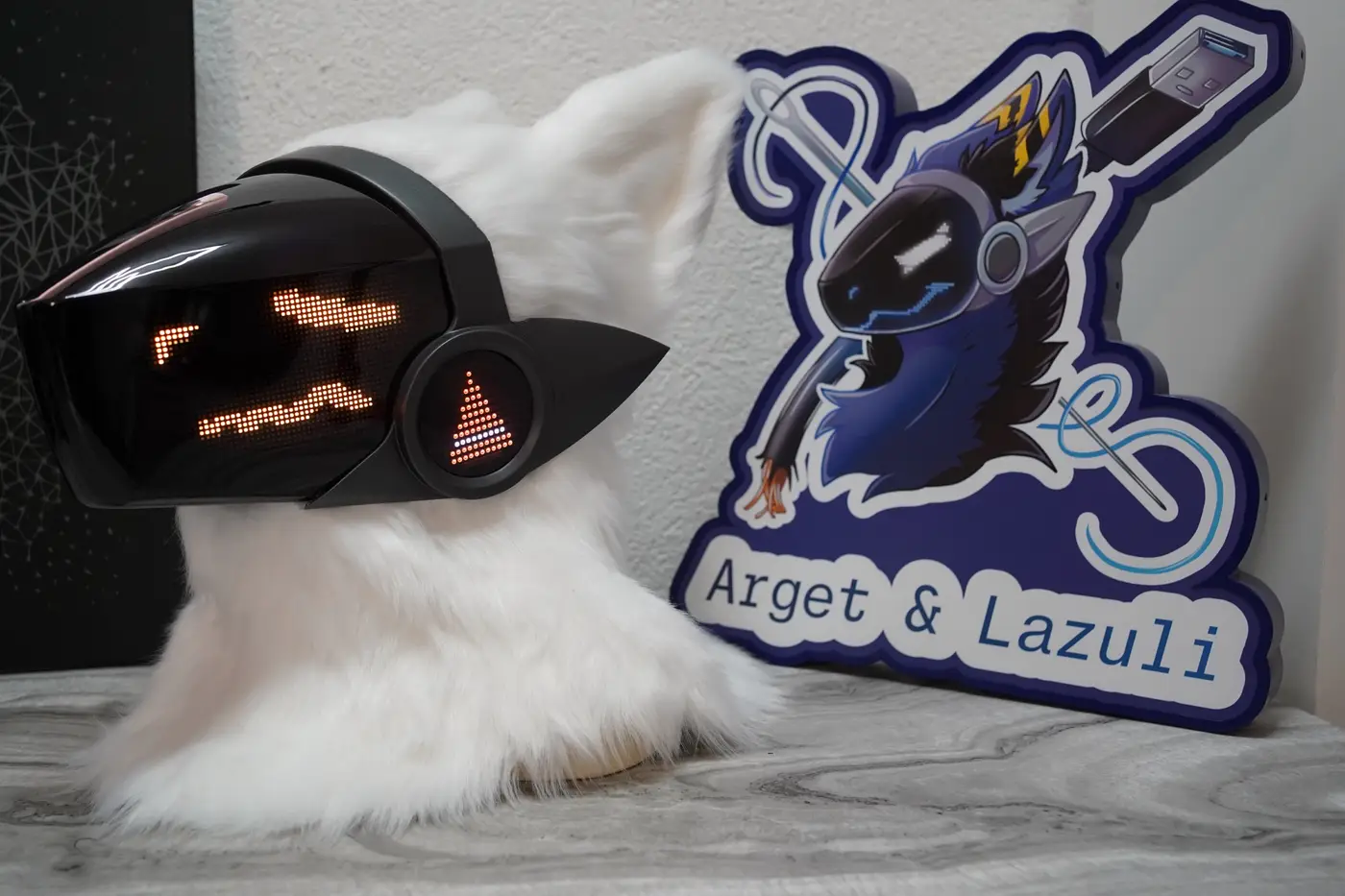 White Protogen head with an orange face on the black LED visor and an orange cheek disc