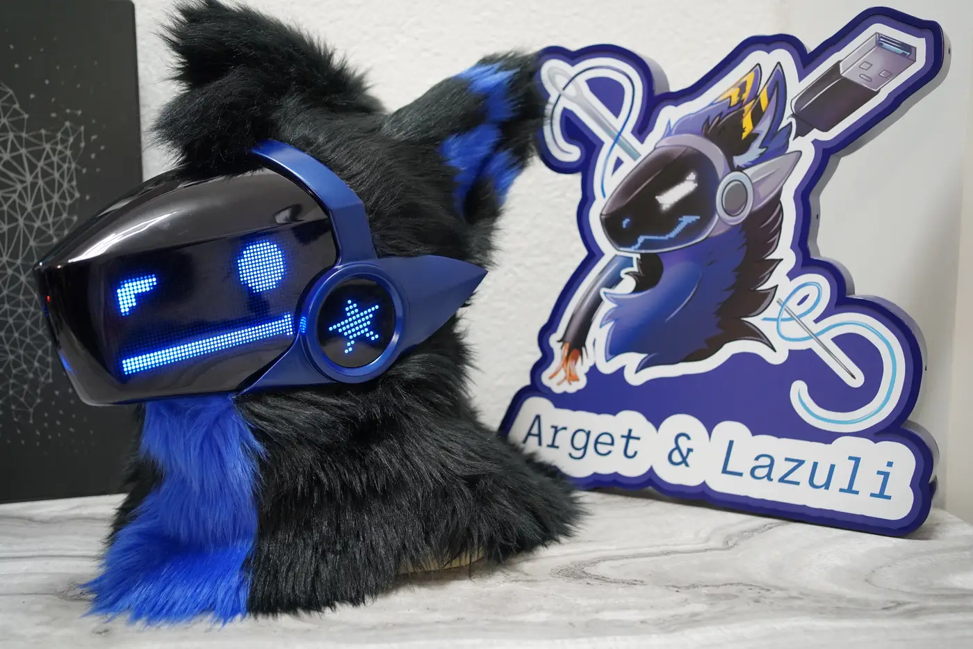 Black Protogen head with a blue bar and a round eye above a straight mouth on the LED visor