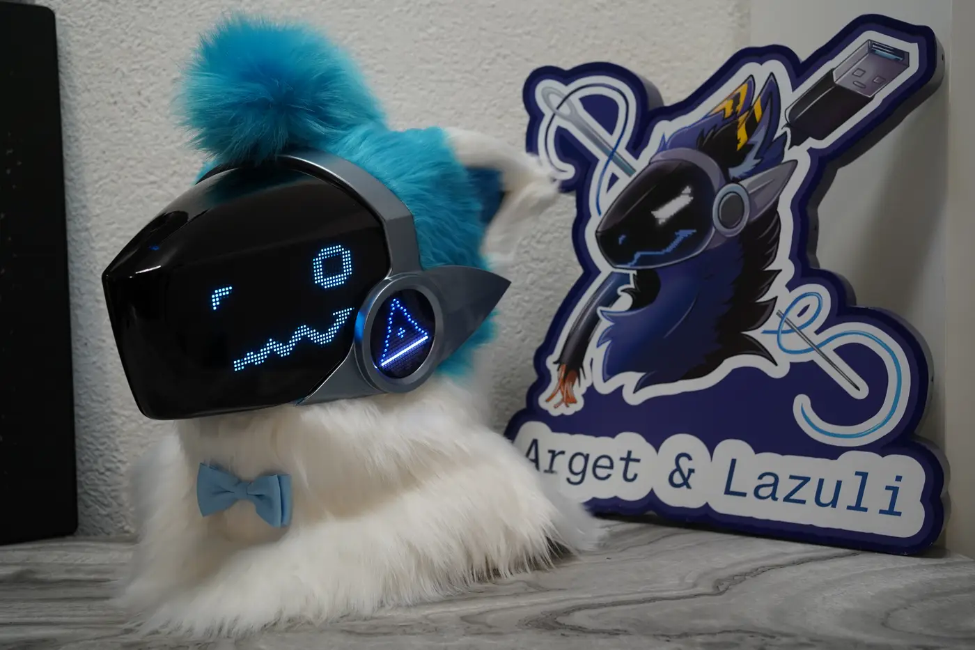 White Protogen head with a round blue pixel eye and a wavy mouth on the black LED visor