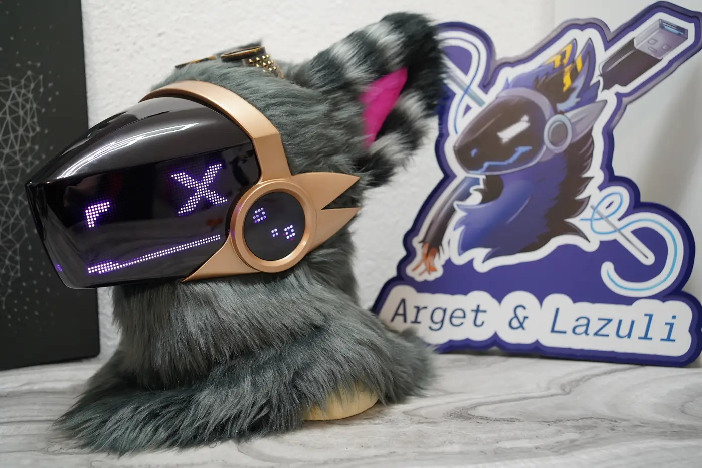 Grey Protogen head with a purple X over one eye on the LED visor