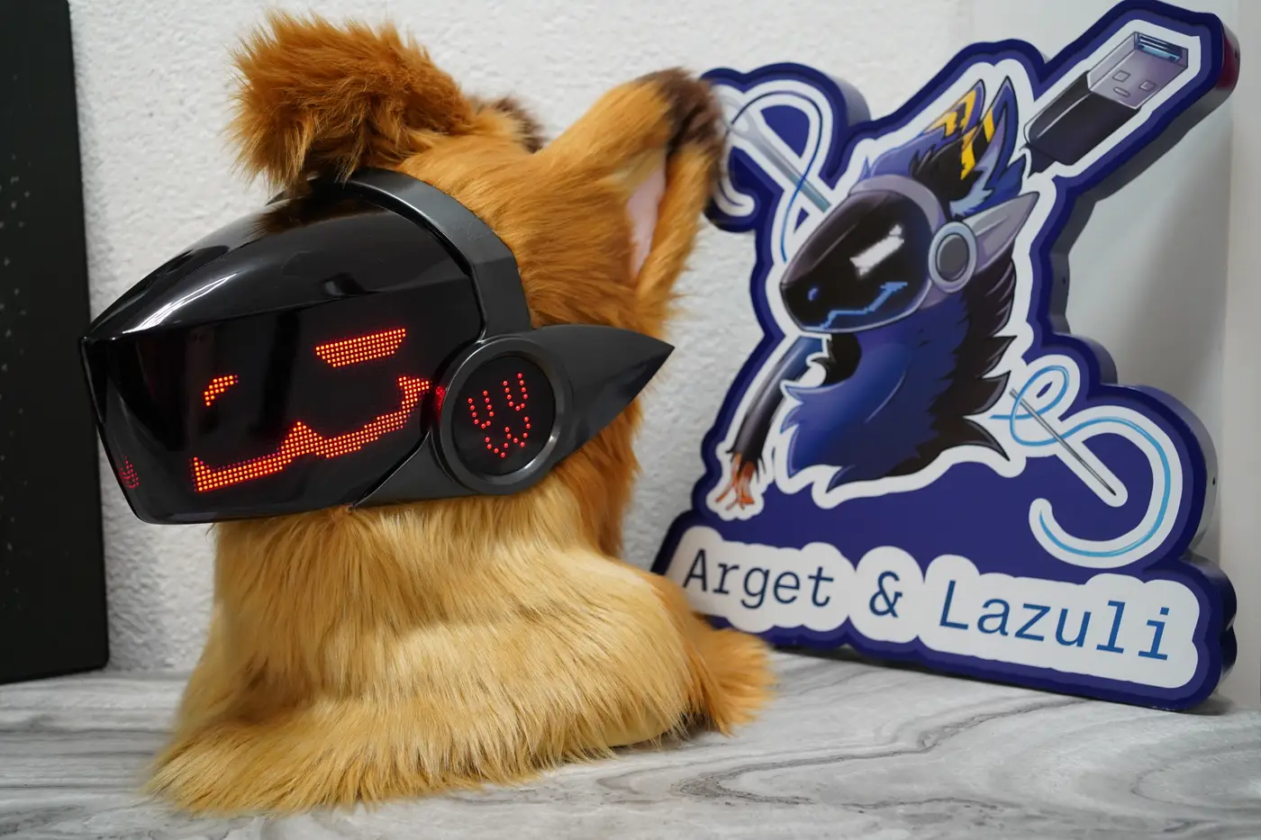 Tan Protogen head with playful red pixel eyes and a red glowing cheek disc on the LED visor