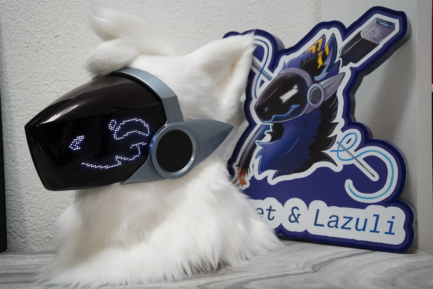 White Protogen head with curled white pixel eyes and a soft pixel smile on the black LED visor