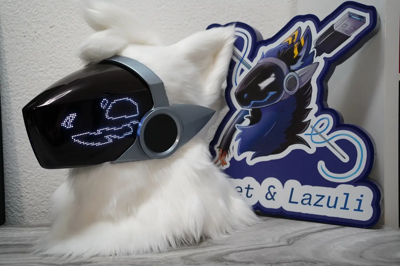 White Protogen head with white pixel eyes and a long wavy mouth on the black LED visor