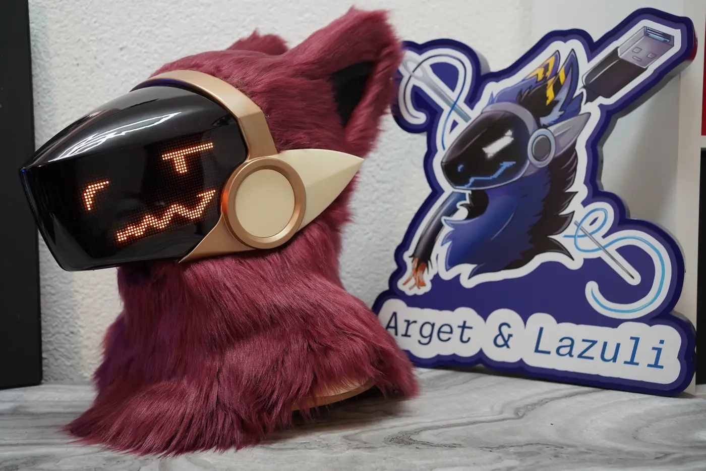 Burgundy Protogen head with a cream frame around the black LED visor