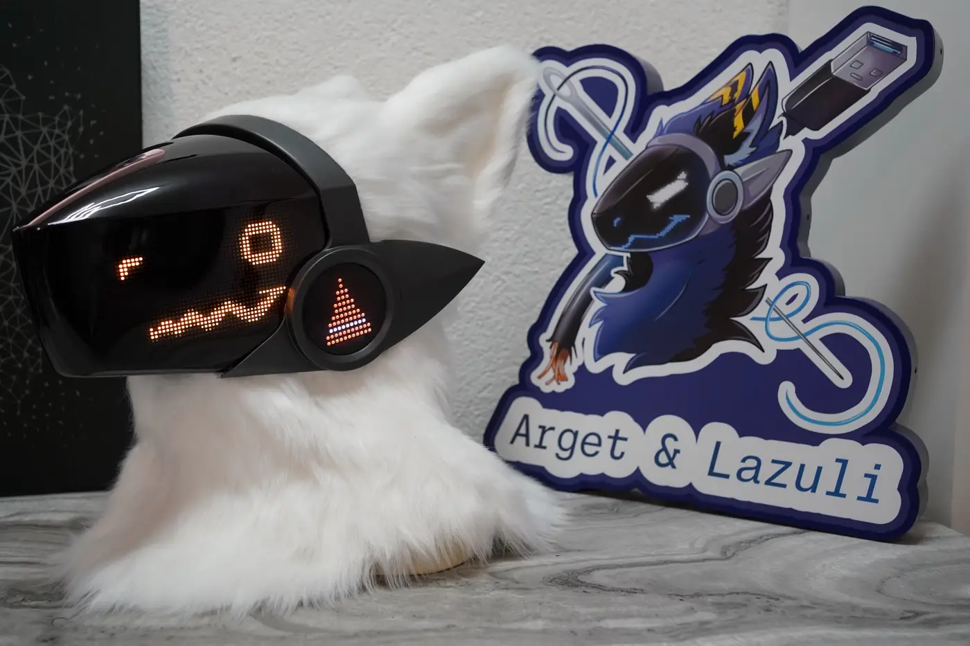 White Protogen head with a lit orange cheek disc beside the black LED visor