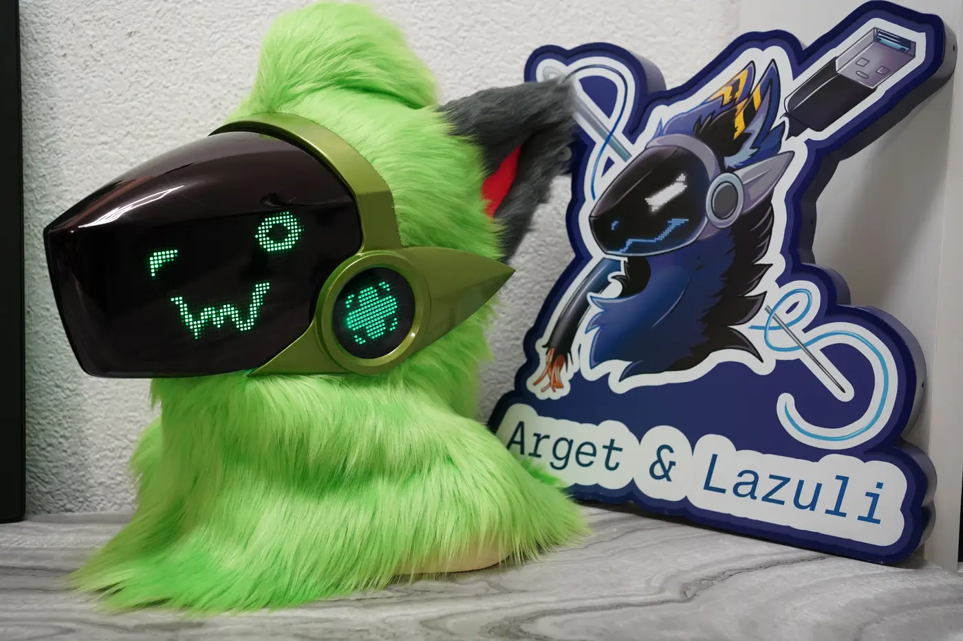 Lime green Protogen head with a round green pixel eye and a w shaped mouth on the black LED visor