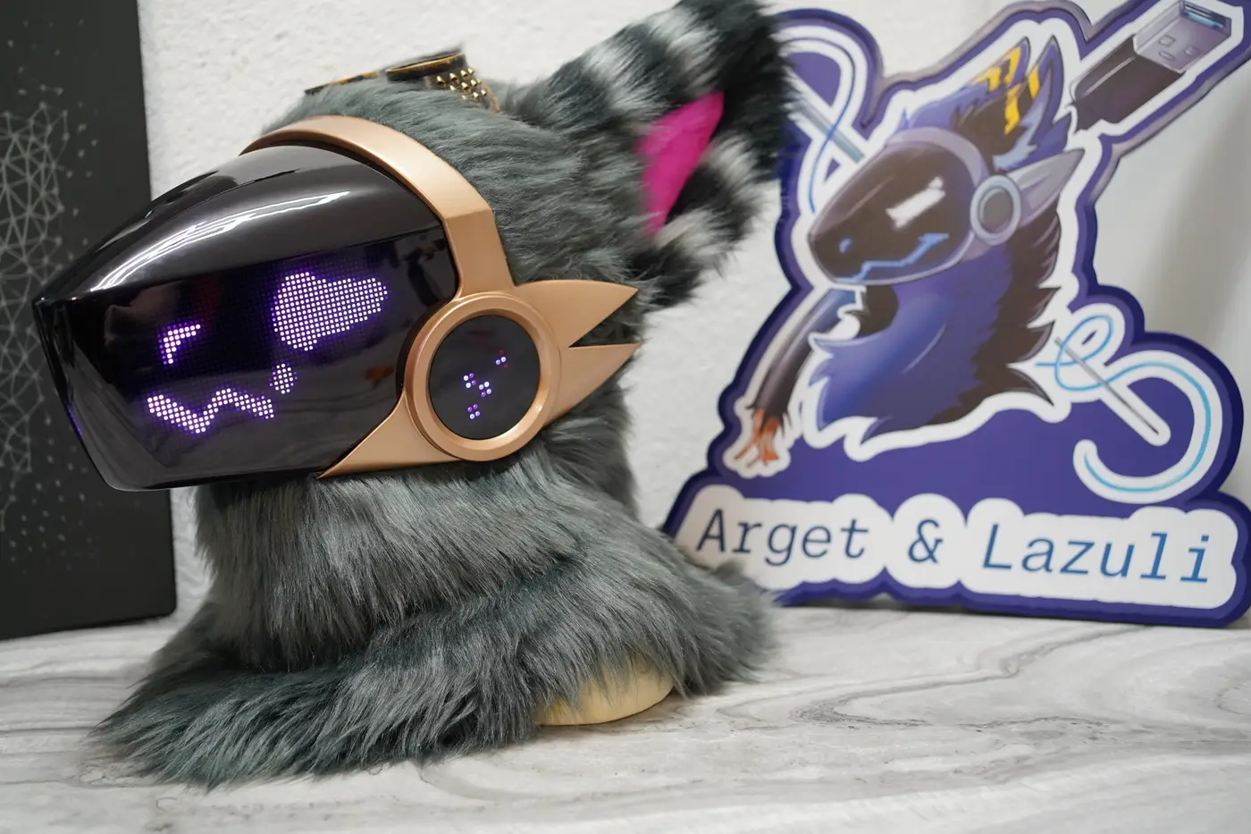 Grey Protogen head with a filled purple shape and a wavy mouth on the LED visor