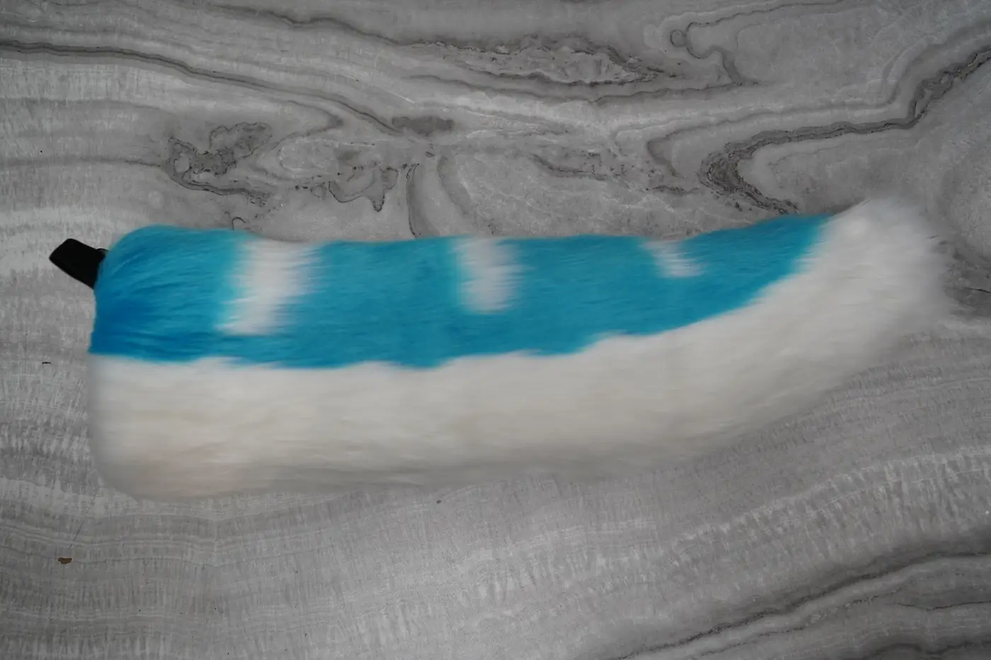 White custom shaped fursuit tail with turquoise stripes, hand sewn for the Protogen mini partial