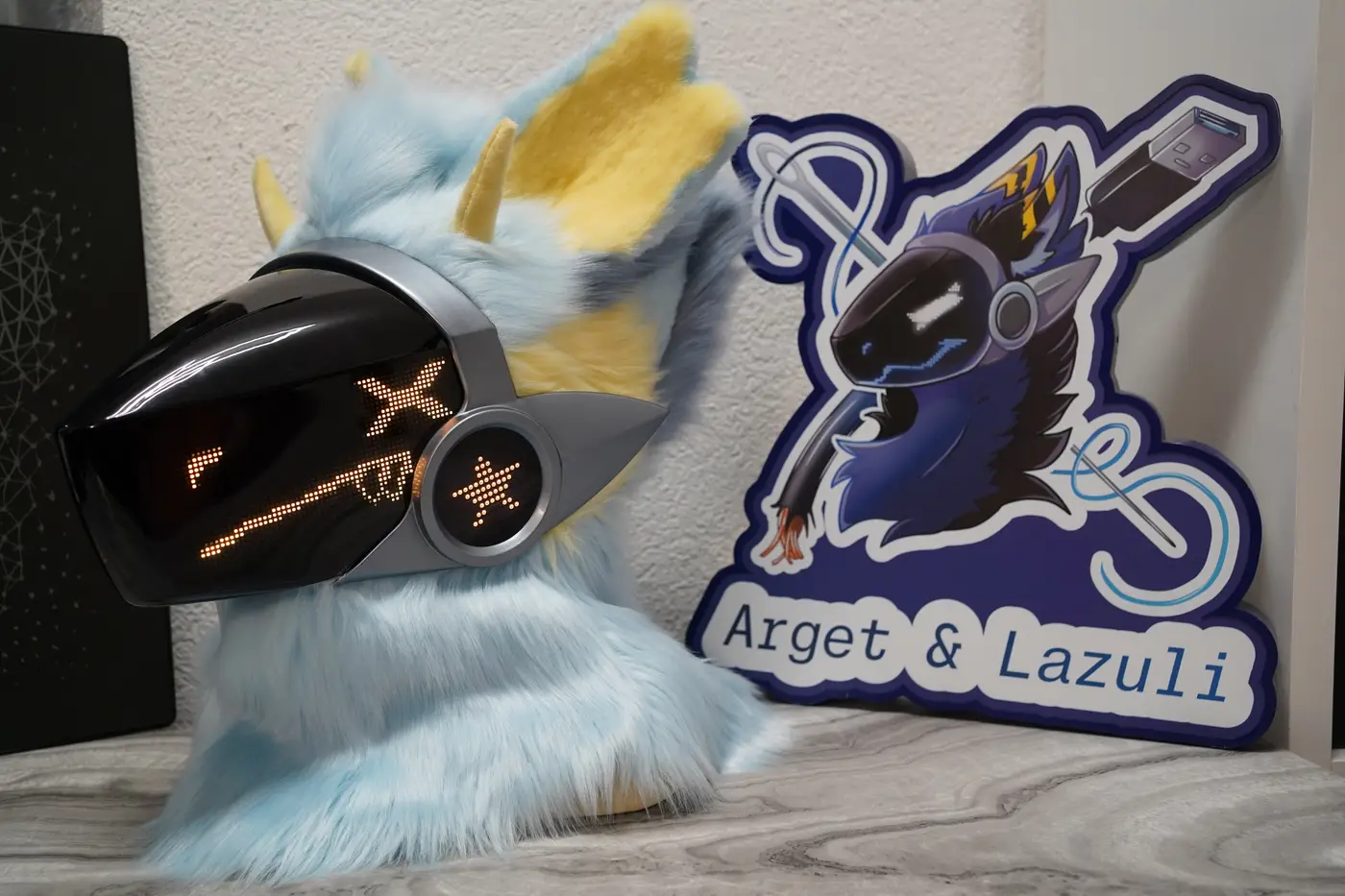 Light blue Protogen head with crossed yellow pixel shapes on the black LED visor