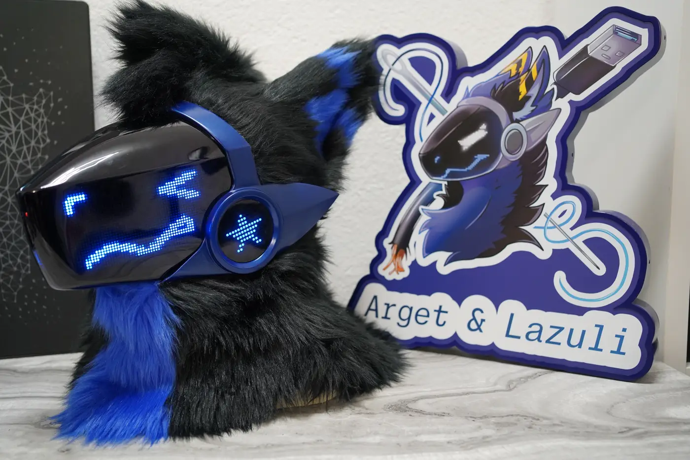 Black Protogen head with blue eyes and a curved mouth on the LED visor