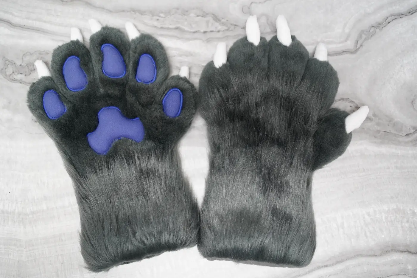 Grey Protogen hand paws with purple pads and white claws