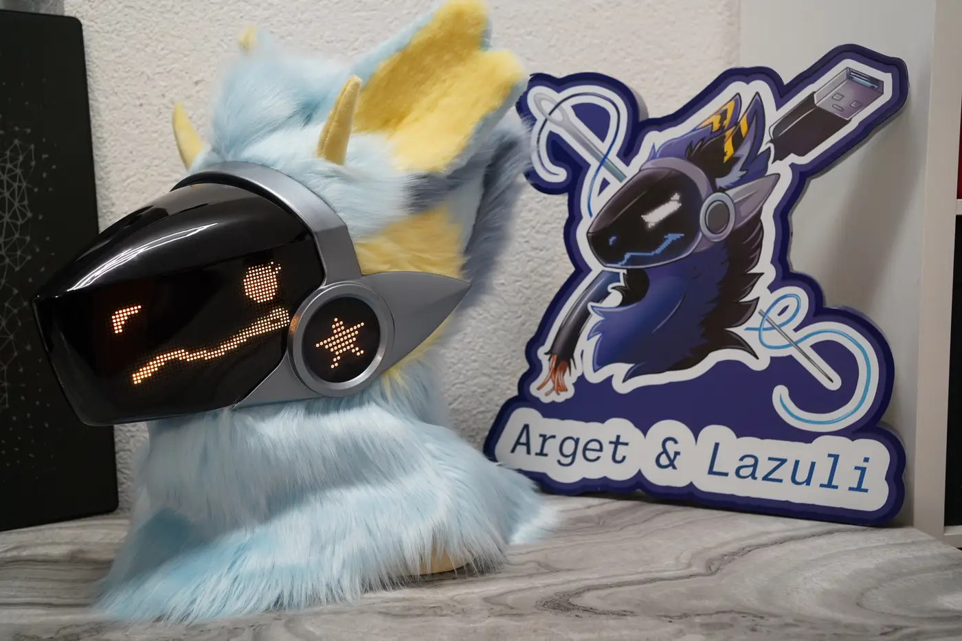 Light blue Protogen head with a dotted yellow pixel expression on the LED visor