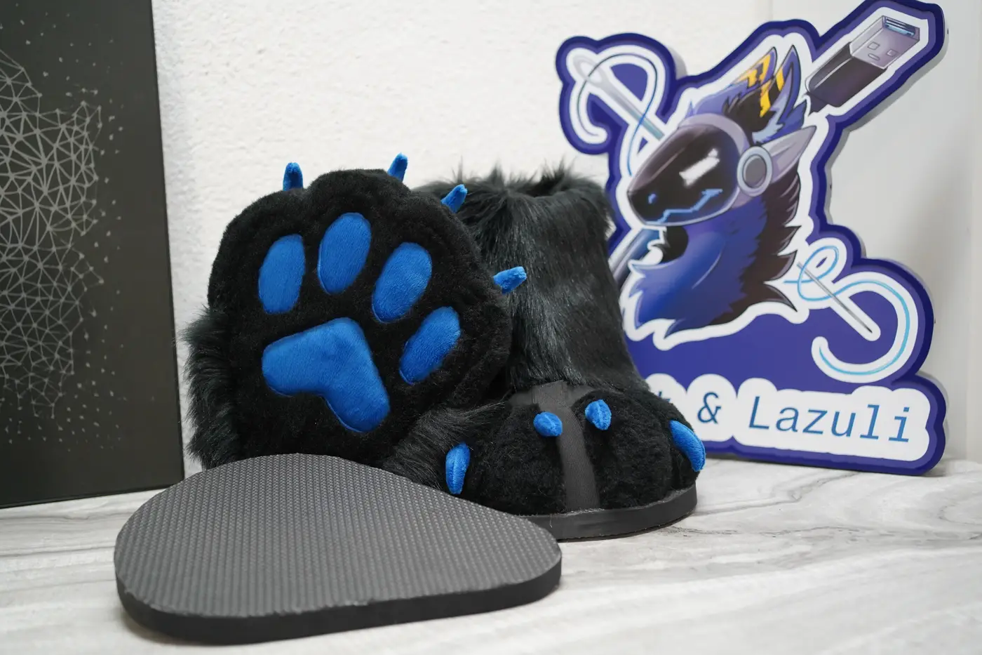 Black Protogen feet paw with blue pads beside its black nonslip sole