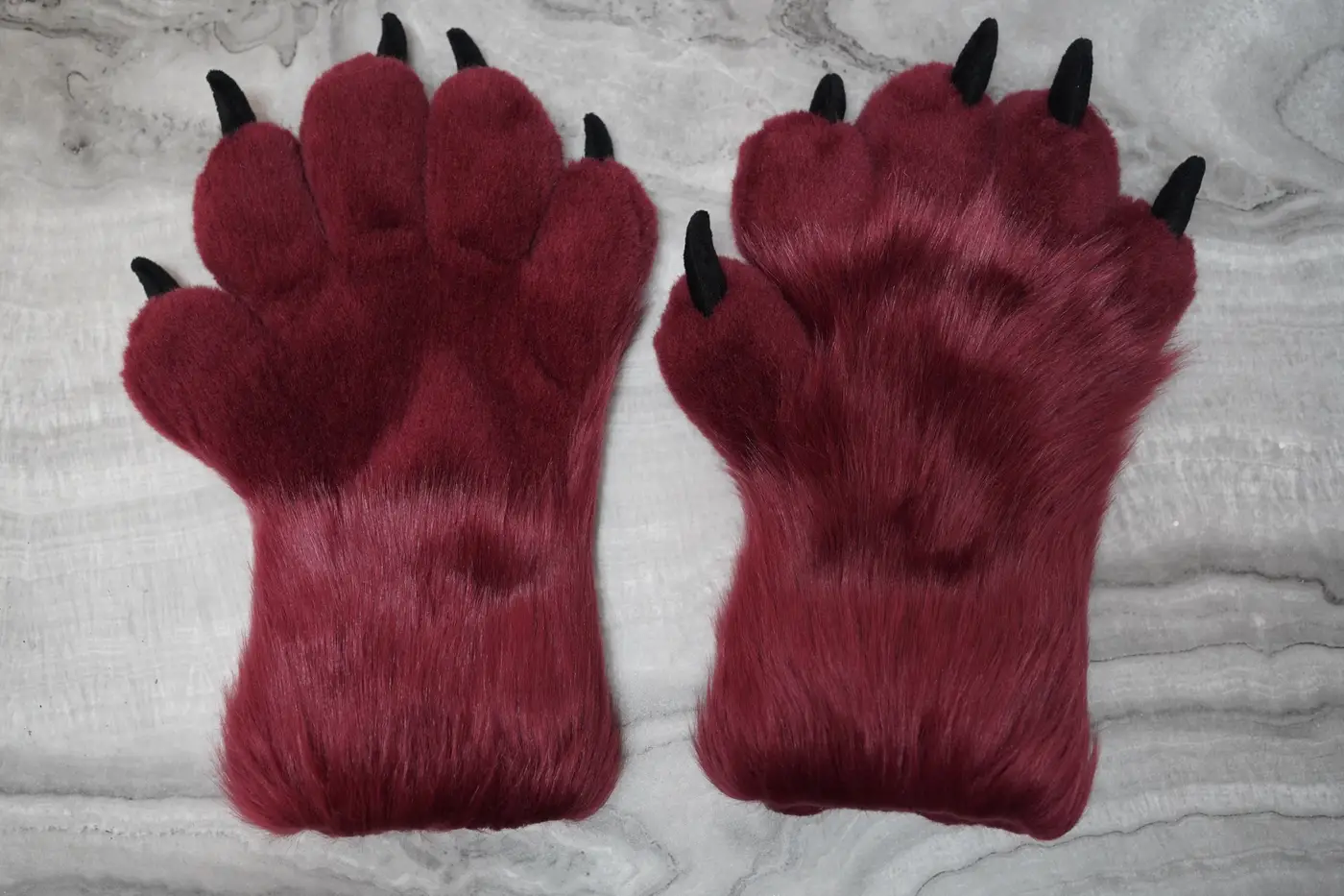 Burgundy Protogen hand paws with black pads and claws