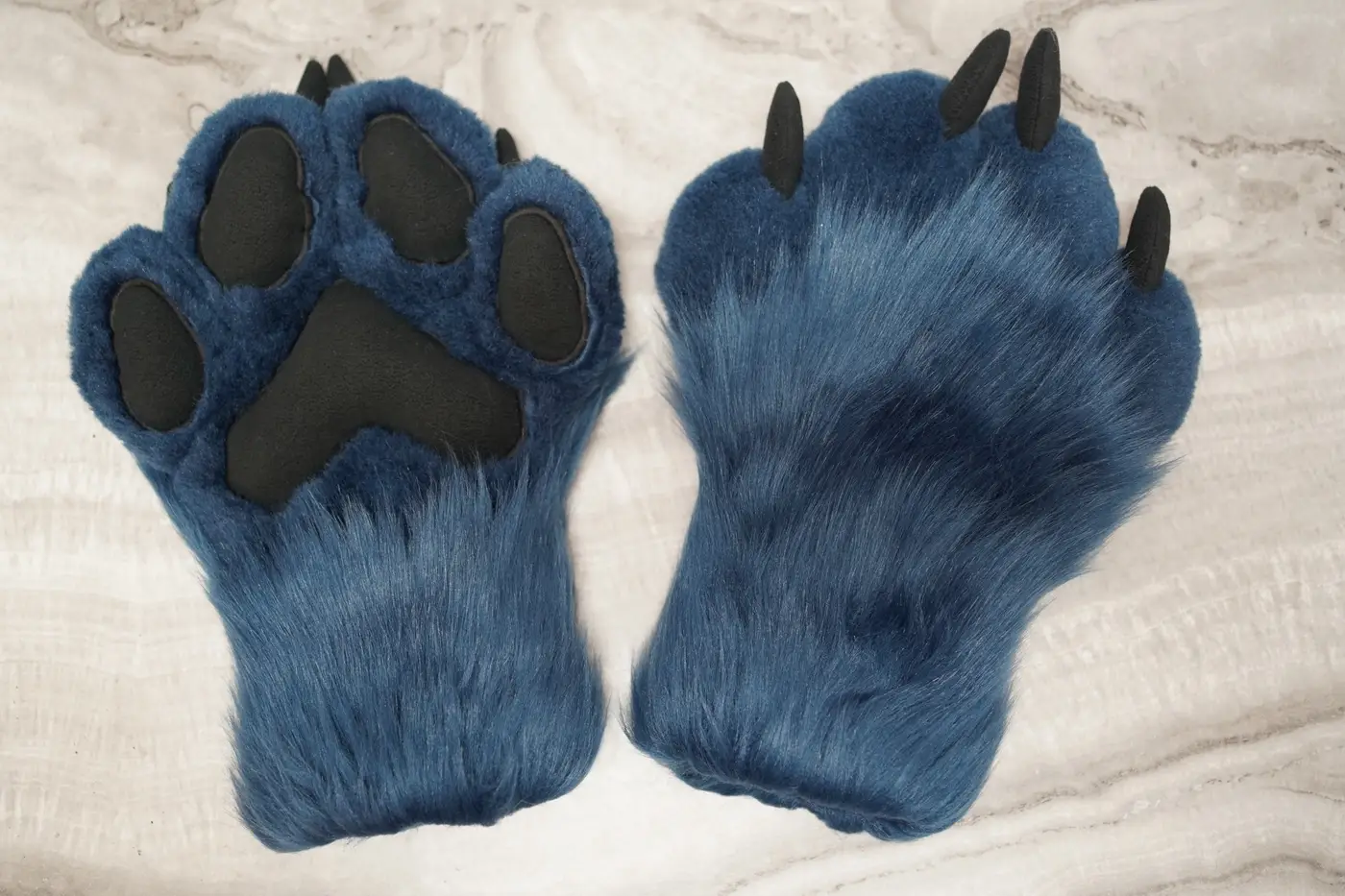 Teal Protogen hand paws with black pads and claws