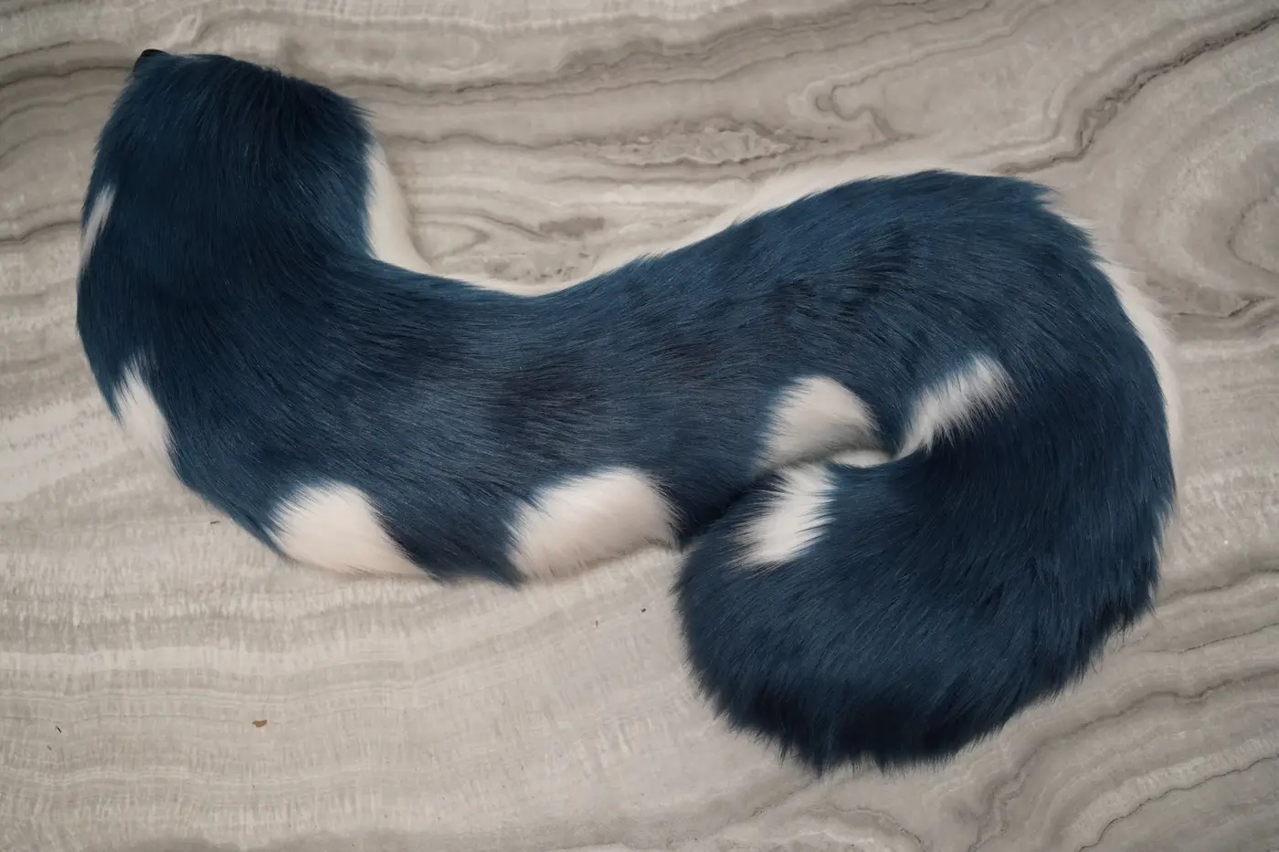 Teal Protogen tail with white spike markings and a curled tip