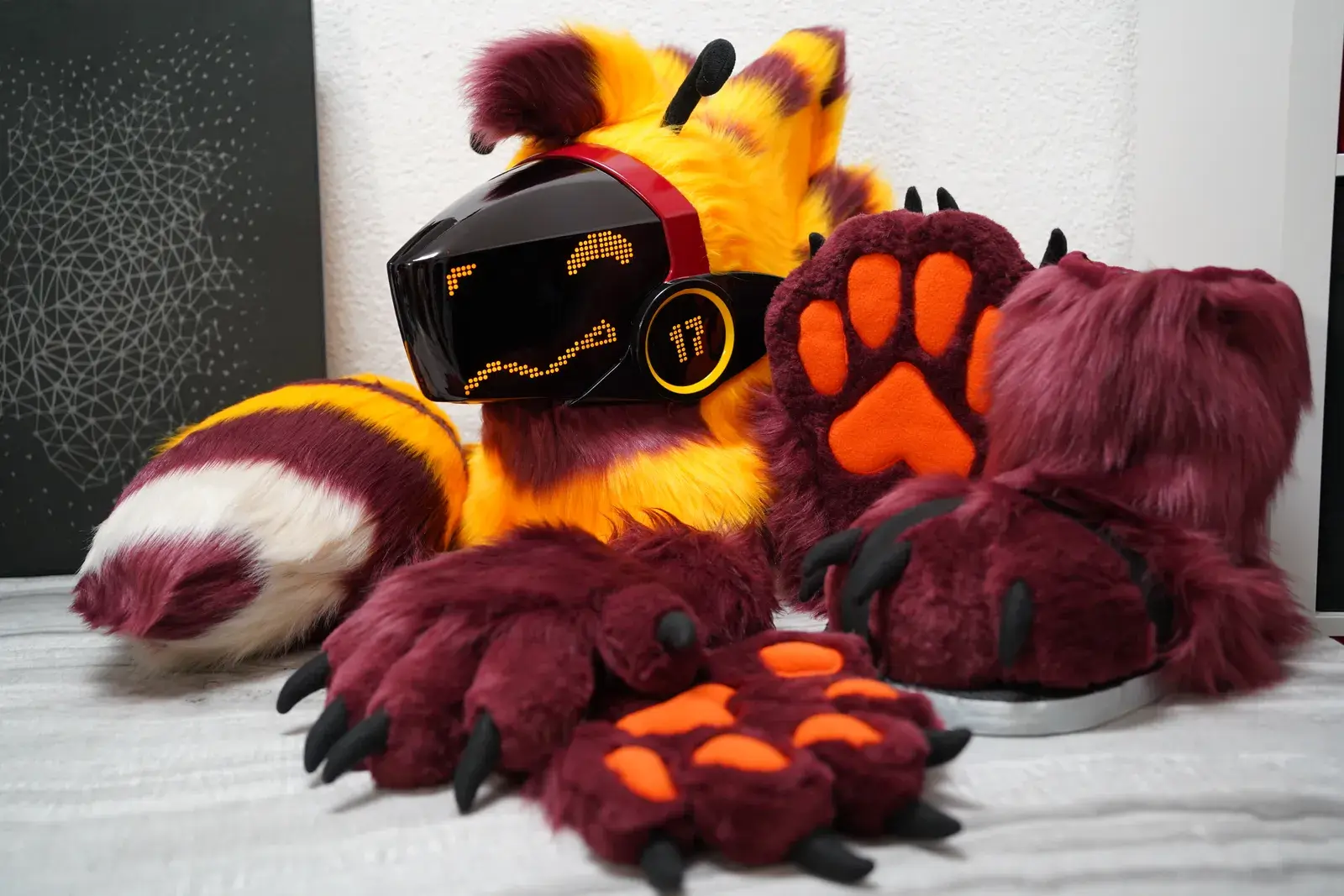 Yellow and dark red Protogen partial: black visor, amber pixel eyes, clawed handpaws, feetpaws and a striped tail, by Arget & Lazuli