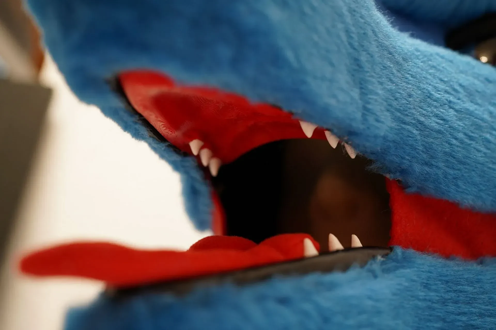 Closeup of the blue Sergal maw with a red tongue and white fangs